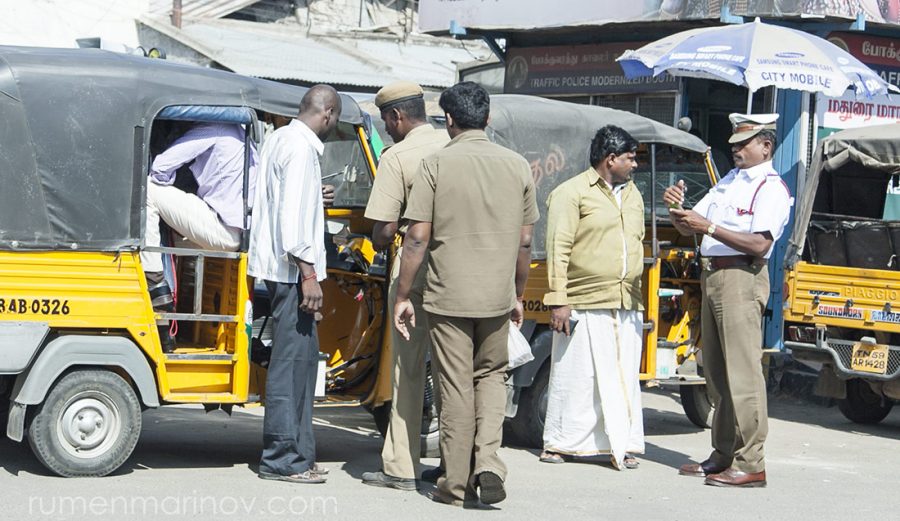 I like the body posture of the cop writing the fine. The rickshaw driver has prepared his wallet to pay the fine (or a bribe if it is more convenient).