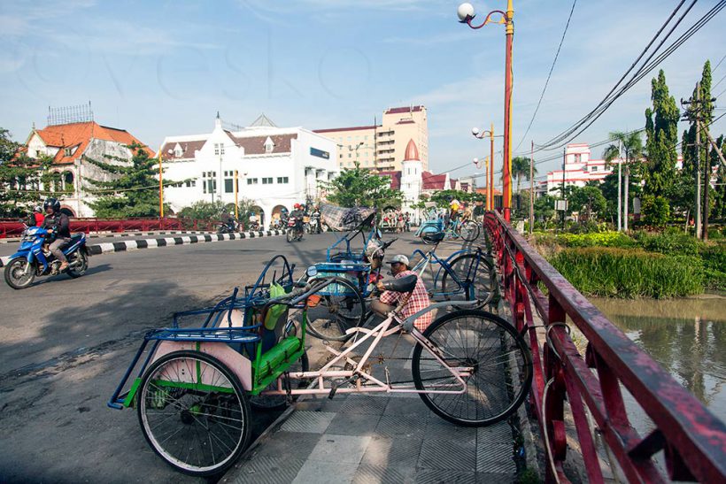 The Red Bridge. A few lethargic bicycle taxis try to get my business. They always sleep in the passenger seat while waiting.