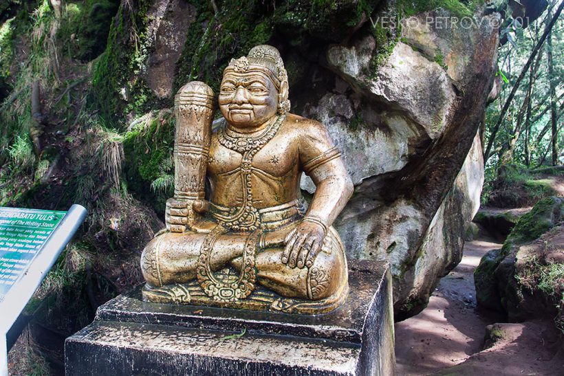 A god statue holding a club that looks like a large male reproductive organ.
