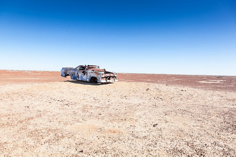 A lone old car in the middle of nowhere.